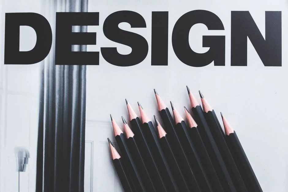 A creative workspace featuring UI design plans, pencils, a smartphone, and other office tools.